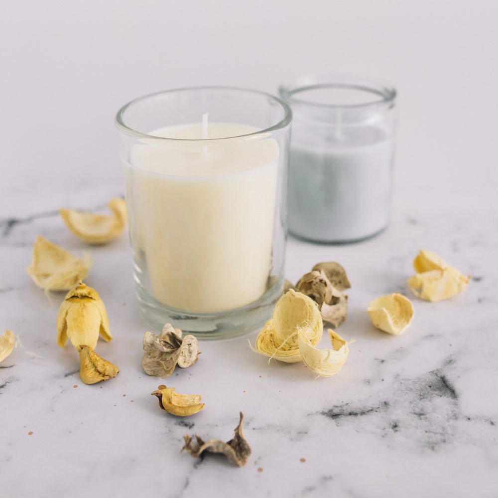 Close-up of dry pods and candle in candleholder on marble surface